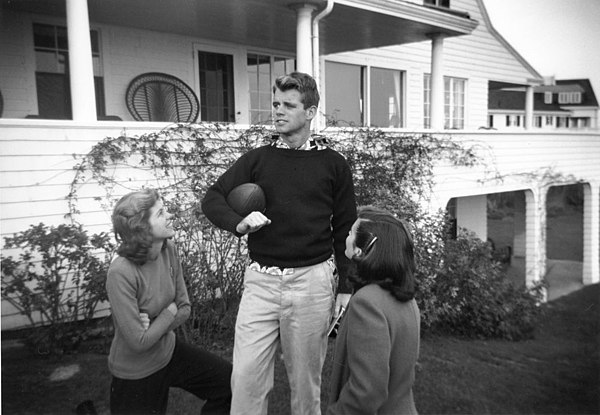 Kennedy (with sisters Eunice and Jean) holding a football at the family's Massachusetts home, c. November 1948