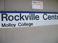 Rockville Centre LIRR Station; Molloy College Sign (modified).JPG