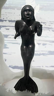 Black sculpture of woman with fingers removed and a fish tail.