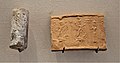 Sceau-cylindre en calcédoine avec empreinte moderne : scène de culte au dieu Assur et à la déesse Ishtar, debout sur deux dragons. Musée du Louvre.