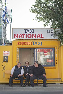 A srteet scene in Nicosia, Cyprus, showing three texi drivers sitting outside a kiosk