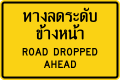 Warning sign on lower level road (Thai and english languages)