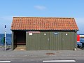 Public toilet and bus stop at the harbour in Aarsdale in front of the Baltic sea on the Danish island Bornholm.