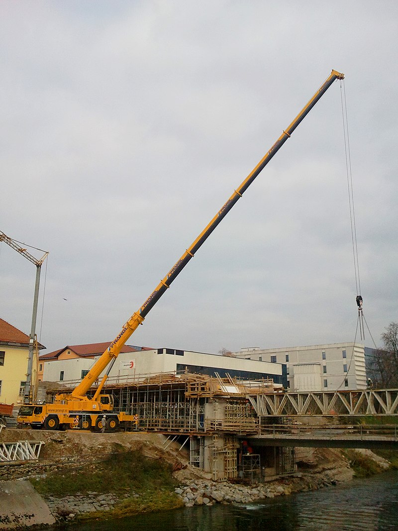 Truck-mounted crane building a bridge.jpg