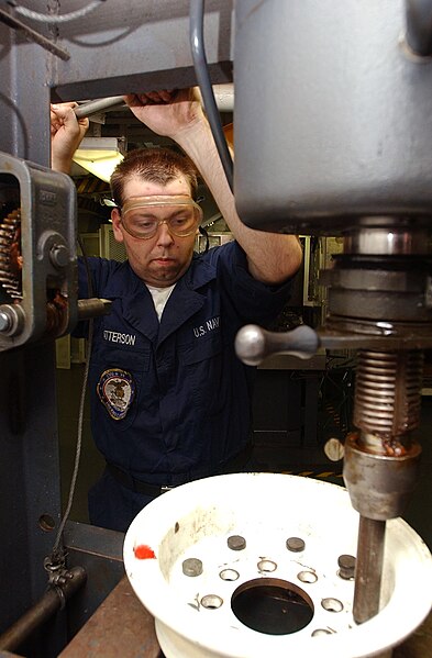 File:US Navy 040909-N-7232R-037 Aviation Support Equipment Technician Airman Eric Patterson of North Judson, Ind., presses pins into a tire rim with a 50 ton hydraulic press.jpg