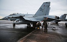 Marines perform maintenance on an F/A-18D of VMFA-242