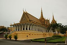 Photo contemporaine d'un palais de style khmer, au toit doré et richement décoré.