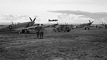 RAF Supermarine Spitfires and a USAAF Boeing B-17 Flying Fortress at Foggia Main airfield. 32 Squadrion RAF Spitfires at Foggia IWM CNA 2663.jpg