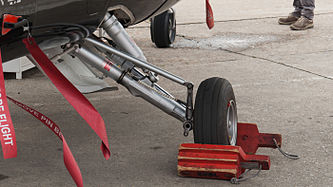 English: Main landing gear of an Alenia Aermacchi M-345 (reg. CPX619, c/n 201) at Paris Air Show 2013. Deutsch: Hauptfahrwerk einer Alenia Aermacchi M-345 (Reg. CPX619, c/n 201) auf der Paris Air Show 2013.