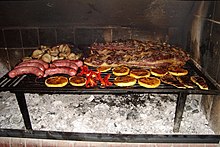 Sliced provoleta grilling on a typical Argentine asado rack Asado2.jpg