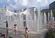 Crown Center Square Fountain. "Dancing Waters" shows with synchronized 60-foot-high (18 m) jets of water run every hour all day on weekends, and at noon & evening hours on weekdays. Crown Center Square Fountain Kansas City MO.jpg