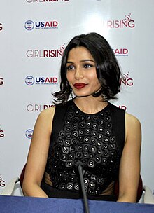 Freida Pinto is looking away from the camera.