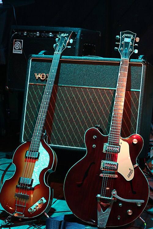 Replicas of McCartney's Höfner bass and Harrison's Gretsch guitar leant against a Vox AC30