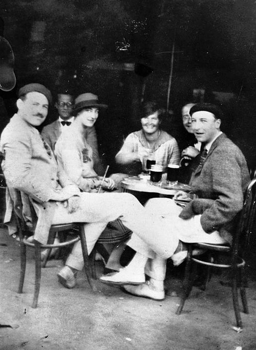 Hemingway (left), with Harold Loeb, Duff Twysden (in hat), Hadley Richardson, Donald Ogden Stewart (obscured), and Pat Guthrie (far right) at a café i