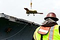 John Dyson, an employee with Naval Facilities Engineering Command, observes as a U.S. Navy X-47B Unmanned Combat Air System demonstrator aircraft is loaded onto the flight deck of the aircraft carrier USS George 130506-N-TB177-411.jpg