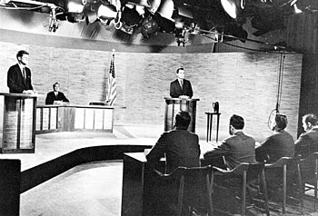 John F. Kennedy (standing, left) and Richard Nixon (standing, right) participate in the second 1960 presidential debate, held in the NBC studios in Washington, D.C., and moderated by Frank McGee. Kennedy Nixon Debate (1960).jpg