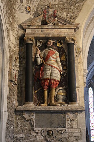 Mural monument in St Mary's Church, Ottery St Mary, to John Cooke (d. 1632) of Thorne. He stands dressed in armour, his helmet resting on the ground, and holds in his left hand the handle of his sheathed sword and in his right hand the baton of a military commander. On the wall of the aedicule behind on either side of his head are shown the arms of Cooke (left) and of Sherman (right). On top is a shield showing Cooke of 9 quarters, the first quarter being Thorne of Thorne Memorial to John Coke of Thorne Esq in St Mary's Church, Ottery St Mary.JPG