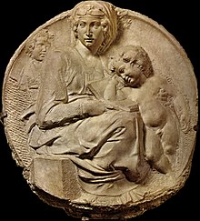 Round marble relief of the Madonna holding a book that the baby Jesus is leaning upon