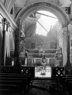 Pvt. Paul Oglesby, of the U.S. 30th Infantry, standing in reverence before an altar in a damaged Catholic Church in Acerno