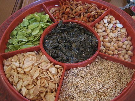 Pickled tea in the center compartment is served in a lahpet ohk with accompanying condiments