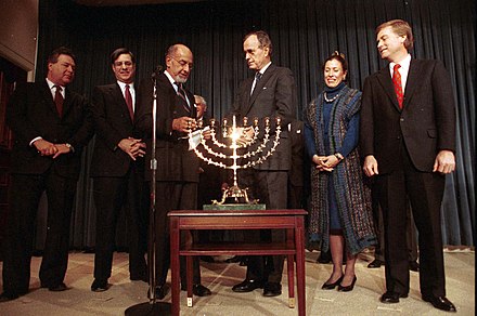George H. W. Bush, Dan Quayle, and Marilyn Quayle participate in a Hanukkah Celebration in 1989