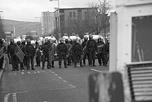 PSNI march in unison, following the trail of loyalists flooding back into East Belfast Riot police march in unison, following the trail of loyalists flooding back into East Belfast.jpg