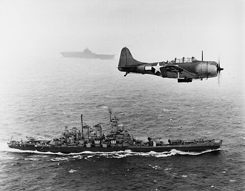 An SBD Dauntless flies patrol over USS Washington and USS Lexington during the Gilbert and Marshall Islands campaign, November 12, 1943.