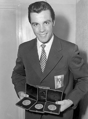 Toni Sailer, the Austrian gold medalist in three disciplines Alpine skiing Toni Sailer with 3 gold olympic medals at Cortina 1956.jpg