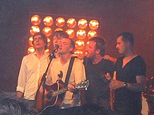Travis performing live on stage together as a group