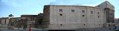 Vista del edificio desde el oeste (plaza de Potugalete). Se ve el edificio herreriano concluido hasta el crucero, el muñón de la torre hundida en 1841 con la cornisa destrozada por el efecto de la caída de las piedras y las ruinas de la colegiata bajomedieval.