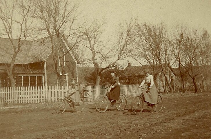 Women on bicycles on unpaved road, US, late 19th century