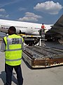 A Diplomatic courier ensures that palletized U.S. Diplomatic pouch material is properly unloaded from an aircraft at Dulles International Airport in Chantilly, VA, June 8, 2009. (43231665864).jpg