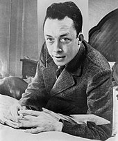French philosopher, novelist, and playwright Albert Camus. Albert Camus, gagnant de prix Nobel, portrait en buste, pose au bureau, faisant face a gauche, cigarette de tabagisme.jpg