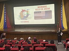 Una sala de proyección, con Carolina Dávila, directora del festival pronunciando su discurso de inauguración.