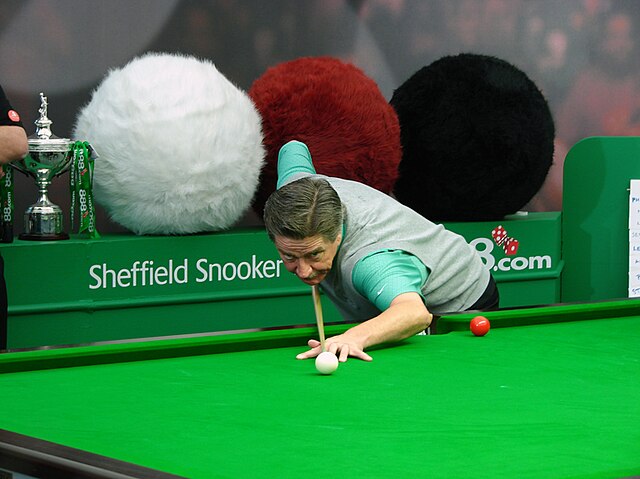 Cliff Thorburn playing at a snooker table