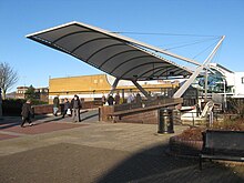 Bridge linking the two parts of the Clyde Shopping Centre. The Clyde Shopping Centre first opened in 1982 on part of the Singer Works. The centre was refurbished in 2003 and re-opened by Queen Elizabeth II. The new canal bridge was designed by RMJM and opened in 2007. Clyde Shopping Centre bridge.jpg