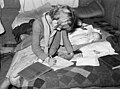 Russell Lee. Daughter of migrant auto wrecker doing her lessons on bed in tent home, Corpus Christi, Texas. February 1939.