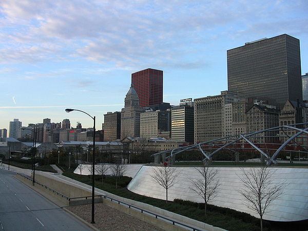 The bridge is a noise barrier along the eastern edge of Millennium Park, with the Historic Michigan Boulevard District in the background.