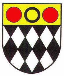Coat of arms of the former Eastwood urban District Council. The black diamonds represent coal mining, the annulet is from the heraldry of the Plumtree family and the red roundels are from the arms of the Grey family of Codnor.