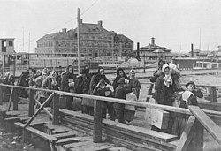 מהגרים המגיעים לאליס איילנד בשנת 1902