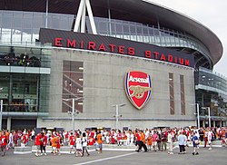 Stadion s logem Arsenal v čele a dav lidí