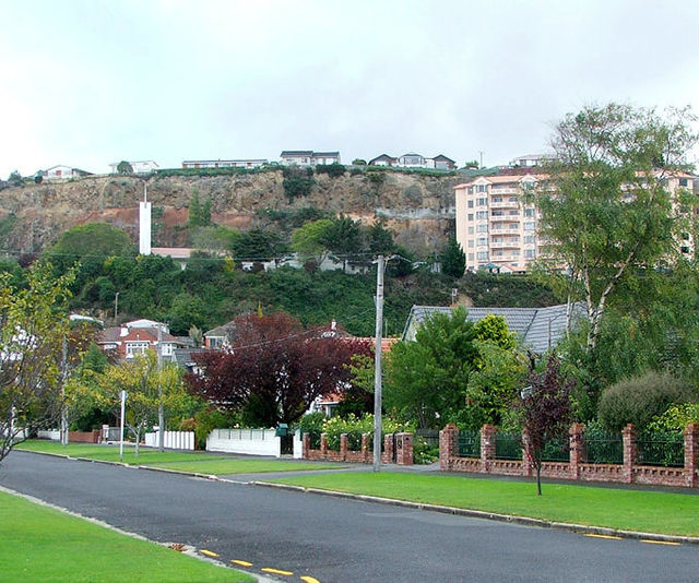The Frances Hodgkins Retirement Village and the spire of Dunedin's LDS Church meetinghouse are visible against the cliffs of the former quarry that li