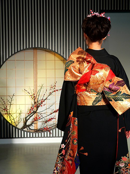 Back of a woman wearing a kimono with the obi tied in the tateya musubi style