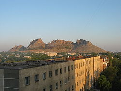 ארבע מפסגותיו של הר סולימאן כפי שהוא נראה מכיוון דרום-מזרח. הפסגה החמישית מוסתרת. בקדמת התמונה בתי העיר אוש