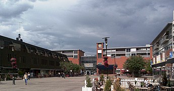 Foto eines gepflasterten Stadtplatzes umgeben von größeren Gebäuden