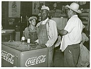 Mexican and Black cotton pickers inside a plantation store (1939). In the 1930s, the term Mexican American was promoted to attempt to define Mexicans "as a white ethnic group that had little in common with African Americans." Mexican and negro cotton pickers inside plantation store, Knowlton Plantation, Perthshire, Miss. Delta. This transient labor is contracted for and brought in trucks from Texas each season. October 1939.jpg
