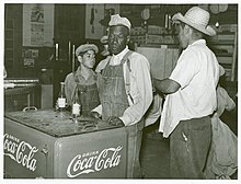 Mexican American boy and African American man at the Knowlton Plantation, Perthshire, Mississippi, in 1939, by Marion Post Wolcott Mexican and negro cotton pickers inside plantation store, Knowlton Plantation, Perthshire, Miss. Delta. This transient labor is contracted for and brought in trucks from Texas each season. October 1939.jpg