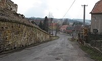 Čeština: Silnice a hřbitovní zeď v Nečemicích. Okres Louny, Česká republika. English: Road and cemetery wall in Nečemice village, Louny District, Czech Republic.