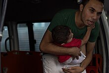 Palestinian man with child, 8 July Palestinian man with child during Operation Protective Edge.jpg