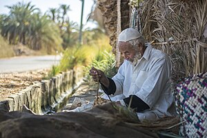 Integrating the rope made of the sackcloth with the final palm leaves weaved piece.